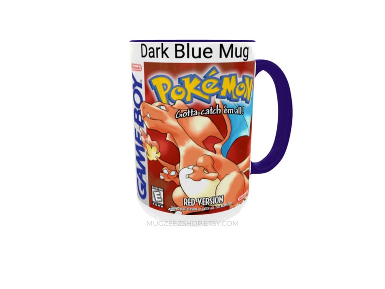 May include: A dark blue ceramic mug featuring a graphic print of the Pokemon Red Version Game Boy game cover. The design includes the orange Charizard character, the Pokemon logo, the text Gotta catch 'em all!, and the Game Boy branding.