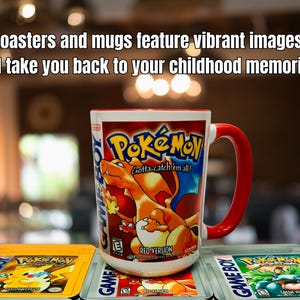 Op de afbeelding: Een witte mok met een rode handgreep en rand met een Pok&eacute;mon-ontwerp met een Charizard-illustratie. De mok staat op een onderzetter met een bijpassend ontwerp. De afbeelding toont ook twee Game Boy-gamecartridges.