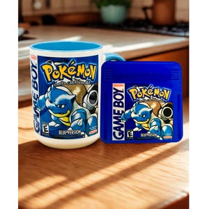 May include: A white ceramic mug with a blue interior and a matching blue Game Boy Pok&eacute;mon Blue Version game cartridge. The mug and cartridge both feature the Pok&eacute;mon logo, the text Game Boy, and an illustration of the character Blastoise.