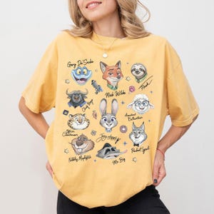A woman wearing a yellow t-shirt with a collage of cartoon animal faces and names printed on it.