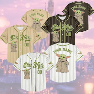 a collection of Star Wars-themed baseball jerseys, each featuring a unique design of the character Baby Yoda. The jerseys are arranged in a grid-like pattern, with some jerseys placed above and below the others. The jerseys are set against a backdrop of a city skyline, adding a sense of depth and context to the scene.
