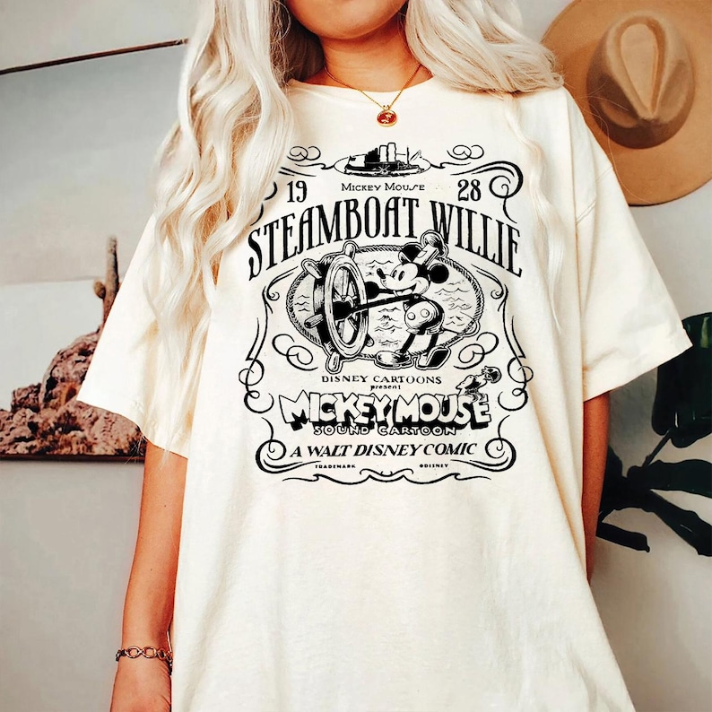 a woman wearing a white steamboat willie t - shirt