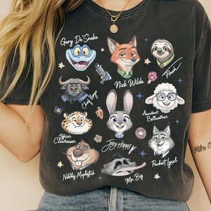 A person wearing a black t-shirt with various cartoon animal characters printed on it, including a frog, a snake, a cow, a pig, a lion, a dog, a rabbit, a cat, and a bear.