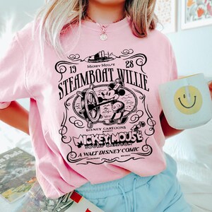 a woman in a pink shirt holding a coffee mug