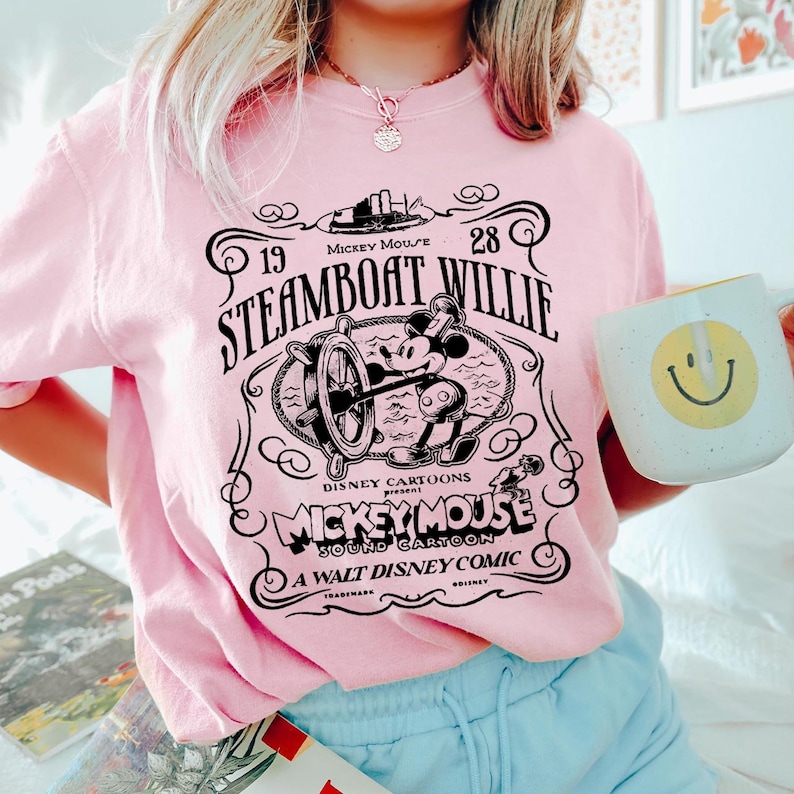 a woman in a pink shirt holding a coffee mug