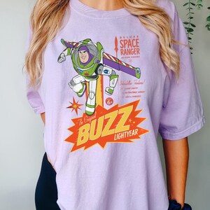 a woman wearing a purple buzz lightyear t - shirt