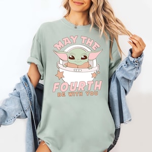 a woman wearing a t - shirt that says, may the fourth be with you