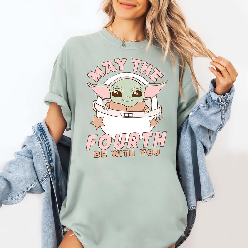 a woman wearing a t - shirt that says, may the fourth be with you