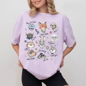 A woman wearing a pink t-shirt with a graphic design of various cartoon animal characters, including a dog, cat, rabbit, and other animals.