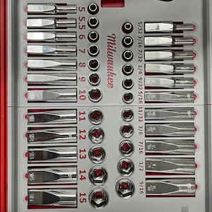 May include: A gray and red tool case with a Milwaukee brand socket set. The set includes a variety of sockets, a ratchet, and extensions. The case has a label that says "A+ DESIGNS".