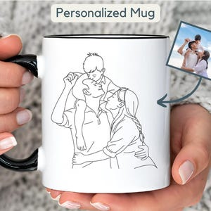 May include: White ceramic mug with a black handle and interior. The mug features a black and white line drawing of a family. A small photo of the family is also shown. The text "Personalized Mug" is at the top.