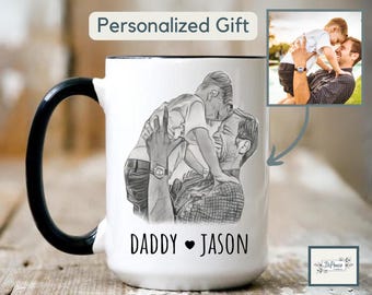 Könnte beinhalten: Weiße Keramiktasse mit schwarzem Henkel und Rand. Die Tasse zeigt eine Bleistiftskizze eines Vaters und Kindes, mit den Worten "DADDY ❤ JASON" darunter. Der Text "Personalized Gift" steht oben.