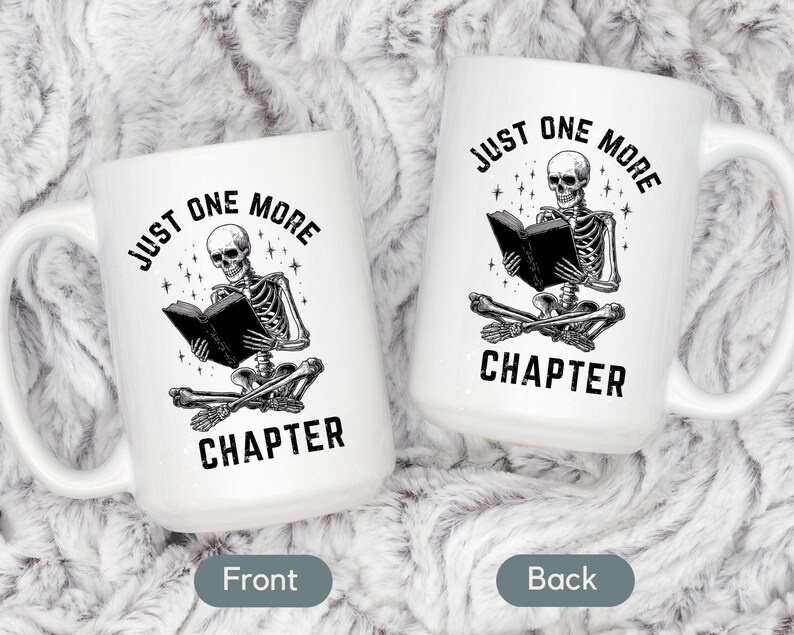 May include: Two white ceramic mugs with a black and white illustration of a skeleton reading a book. The text "JUST ONE MORE CHAPTER" is printed on the mugs. The mugs have a large handle.