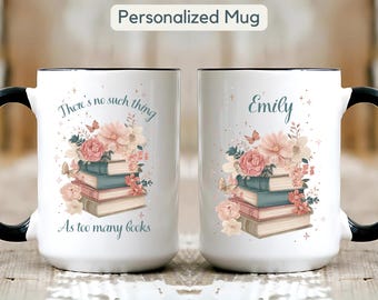 May include: White ceramic mug with a black handle and rim, featuring a floral and book design. The mug has the text "There's no such thing As too many books" and "Emily" printed on it. The mug is labeled "Personalized Mug".