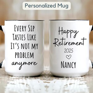 Puede incluir: Taza de cerámica blanca con asa y borde negros. La taza presenta el texto "EVERY SIP TASTES LIKE IT'S NOT MY PROBLEM anymore" en un lado y "Happy Retirement 2025" con un corazón y el nombre "NANCY" en el otro.