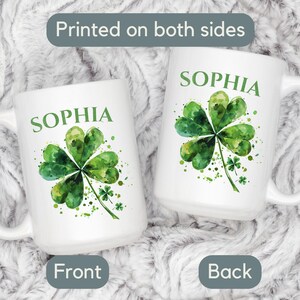 K&ouml;nnte beinhalten: Wei&szlig;e Keramiktasse mit einem gr&uuml;nen Aquarell-Kleeblatt-Design und dem Namen "Sophia", der auf beiden Seiten aufgedruckt ist.