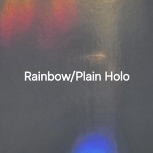 Puede incluir: Superficie gris oscuro con efecto hologr&aacute;fico arco&iacute;ris y el texto "Rainbow/Plain Holo". La imagen tiene una apariencia texturizada con &aacute;reas de luz amarilla, roja, verde y azul.