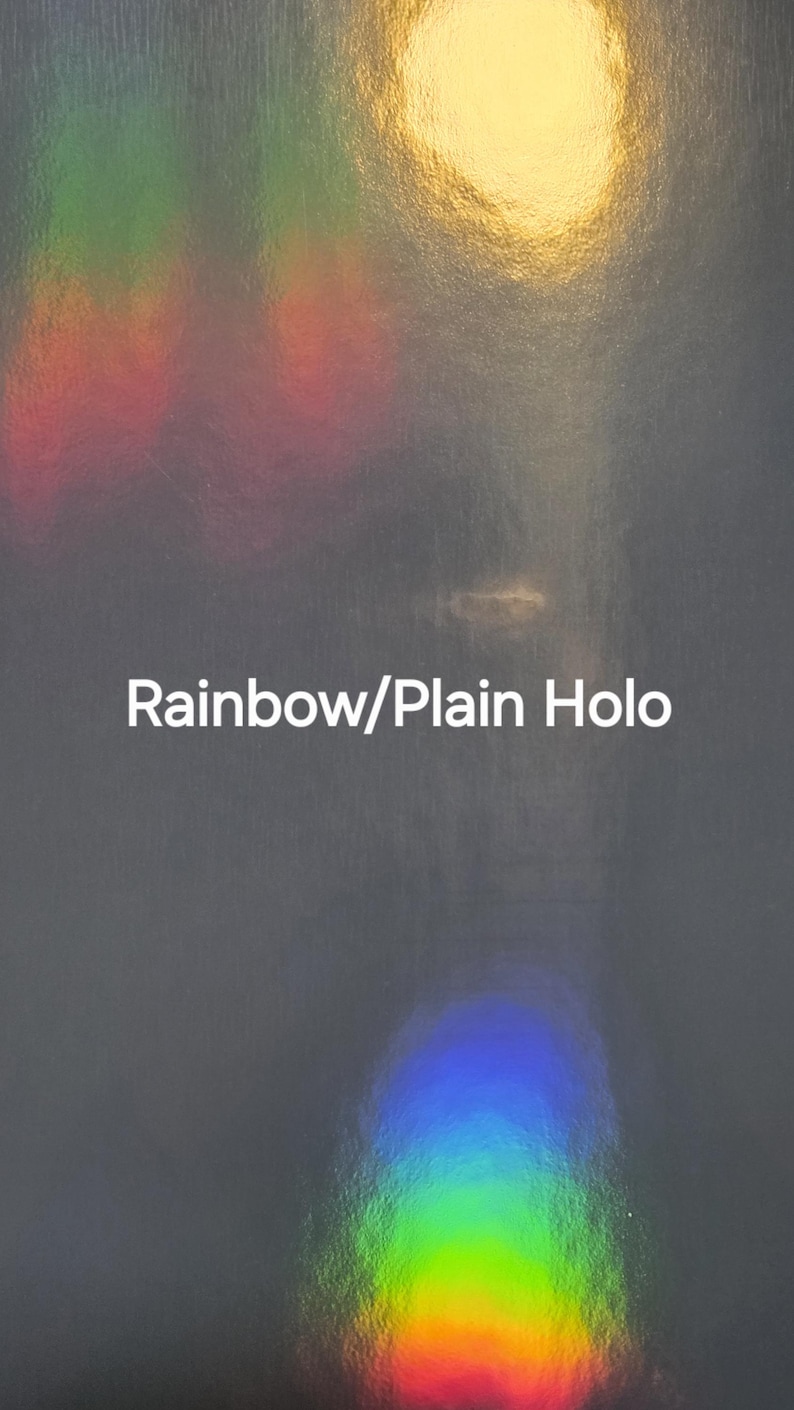 Puede incluir: Superficie gris oscuro con efecto hologr&aacute;fico arco&iacute;ris y el texto "Rainbow/Plain Holo". La imagen tiene una apariencia texturizada con &aacute;reas de luz amarilla, roja, verde y azul.