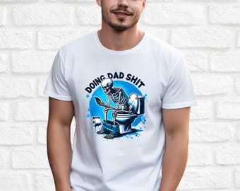 May include: White t-shirt with a blue and white graphic of a skeleton sitting on a toilet with the text "Doing Dad Shit".