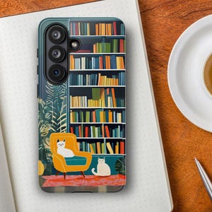 Peut inclure: Une coque de smartphone rectangulaire présentant une illustration colorée d'une grande bibliothèque remplie de livres multicolores, un fauteuil jaune moutarde, deux chats blancs et des plantes vertes, sur fond bleu sarcelle et tapis rose.