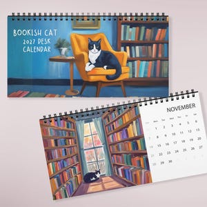 May include: A 2027 desk calendar titled Bookish Cat featuring a black and white cat on an orange chair in a library. The calendar includes a spiral binding and a monthly page for November showing a library scene with a cat and a window view.