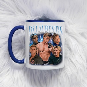 Puede incluir: Taza de cerámica blanca con asa e interior azules. La taza presenta un collage de imágenes y el texto "DiLaurentis, Brice University". Las imágenes son de un hombre en varias poses.