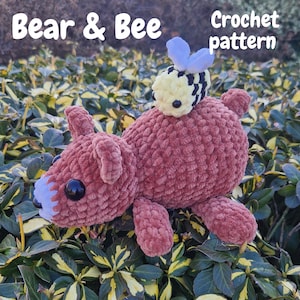 May include: A handmade crochet bear in a reddish-brown color with a small yellow and black bee on its back. The bear has black eyes and a light blue snout. The text "Bear & Bee Crochet pattern" is visible in the image.