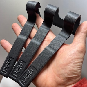 May include: Three black tyre levers with the word "Poltt" printed on each. The levers are made of a textured material and have a hook shape at one end.