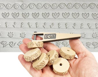 Könnte beinhalten: Ein beiges Blumenmuster-Set mit einem Griff und mehreren runden Stempeln. Die Stempel zeigen verschiedene Blumendesigns, darunter Tulpen, Gänseblümchen und andere stilisierte Blumen. Der Text "Pott'r Floral Pattern Set 1" befindet sich unten.