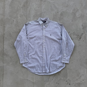 May include: A long-sleeved, button-down shirt with a white and blue checkered pattern. The shirt has a small embroidered logo on the left chest.