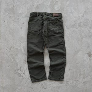 May include: Dark green corduroy pants with a brown leather patch on the back pocket that says "Armani Jeans".