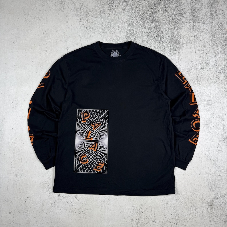 May include: Black long-sleeve t-shirt with an orange graphic of the word "PALACE" in a distorted, geometric design. The sleeves have the word "PALACE" printed vertically in orange.