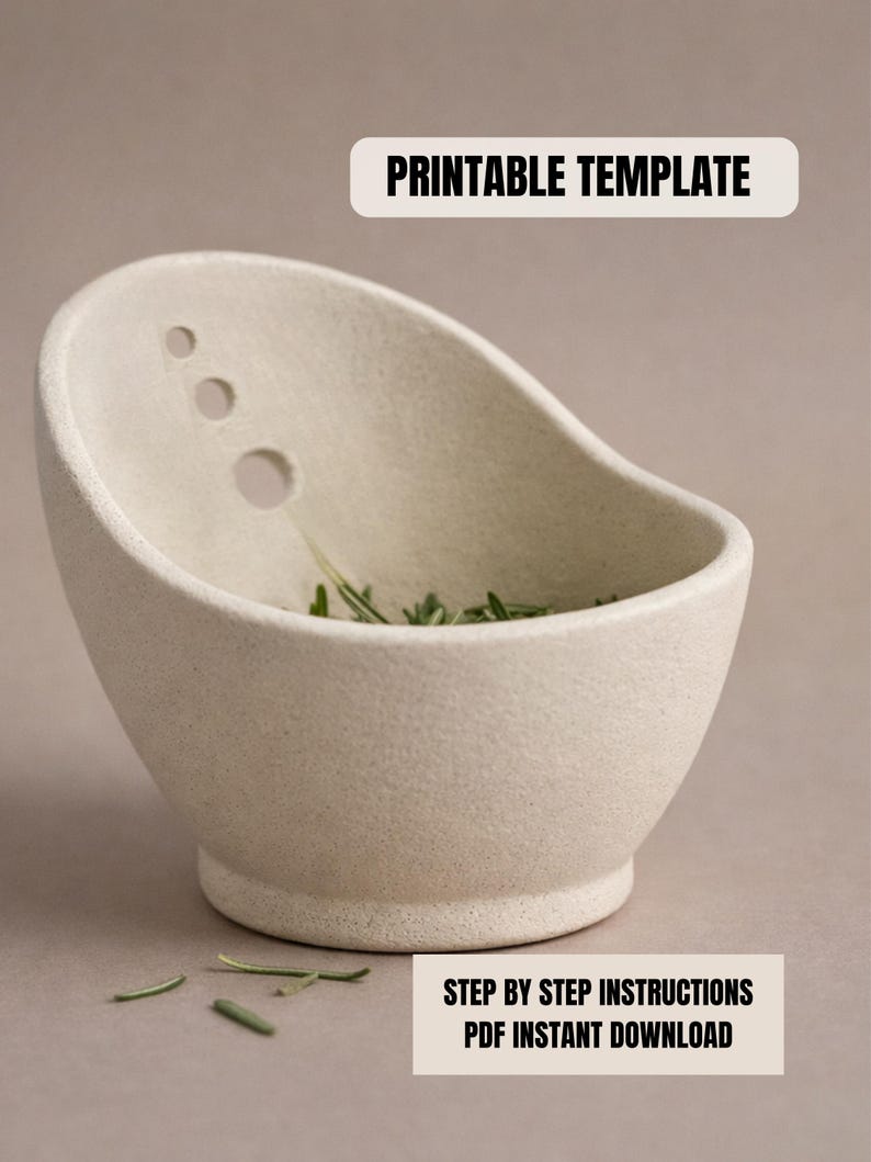 a white ceramic bowl with a few holes in it, placed on a surface with some green leaves scattered around it.