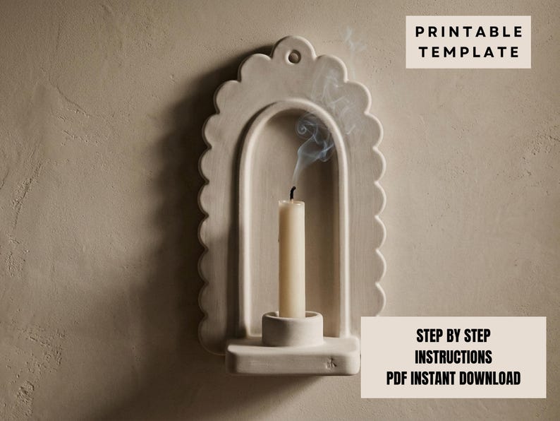 a white candle holder with a lit candle inside, set against a plain beige wall.