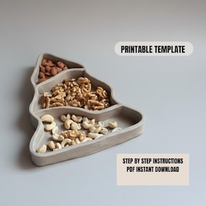 Puede incluir: Una bandeja de servir en forma de árbol de color gris claro llena de almendras, nueces y anacardos. La bandeja tiene tres compartimentos separados. El texto de la imagen dice "PRINTABLE TEMPLATE" y "STEP BY STEP INSTRUCTIONS PDF INSTANT DOWNLOAD".