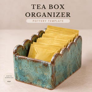 May include: A rectangular ceramic tea box organizer with a scalloped top edge and a mottled teal and brown glaze. The container is filled with several gold-colored tea bags. Text above reads TEA BOX ORGANIZER POTTERY TEMPLATE and DIGITAL DOWNLOAD PDF.