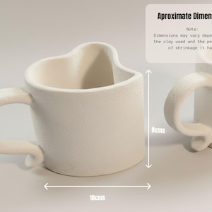 May include: Off-white ceramic mug with a heart-shaped top and a curved handle. The mug is approximately 8 cm tall and 10 cm wide. The text on the image says "Approximate Dimensions".