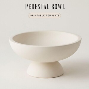 A simple, minimalist pedestal bowl sits on a plain white background.