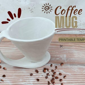 May include: White ceramic coffee mug shaped like a pour-over coffee filter with a handle. The mug is sitting on a wooden surface with coffee beans scattered around it. The text "Coffee Mug Printable Template" is written above the mug.