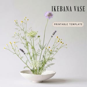 Op de afbeelding: Een witte, ondiepe, keramische Ikebana vaas bevat een bloemstuk. Het arrangement bevat lavendel, gele en witte bloemen met groene stelen. De tekst "IKEBANA VASE" en "PRINTABLE TEMPLATE" worden weergegeven.