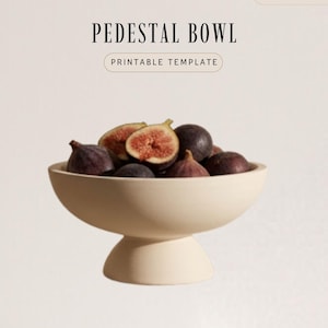 a pedestal bowl filled with various fruits, including figs and kiwi.