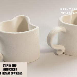 May include: Two off-white ceramic mugs with heart-shaped tops and curved handles. The mugs have a textured surface and are displayed on a light background. Text on the image reads "PRINTABLE TEMPLATE" and "STEP BY STEP INSTRUCTIONS PDF INSTANT DOWNLOAD".