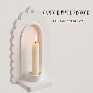 Puede incluir: Un aplique de pared para vela blanco con forma de arco, borde festoneado y un pequeño orificio en la parte superior para colgar. Una vela cónica de color crema con la llama encendida descansa en la base. El texto CANDLE WALL SCONCE PRINTABLE TEMPLATE es visible.