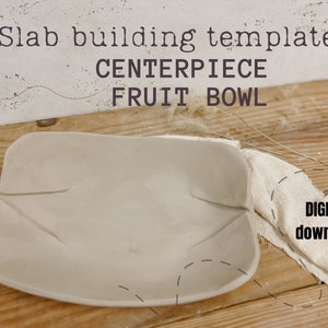 May include: A white ceramic bowl, shaped like a fruit bowl, is on a wooden surface. The bowl is a slab building template for a centrepiece fruit bowl. The text "DIGITAL download" is visible in the image.