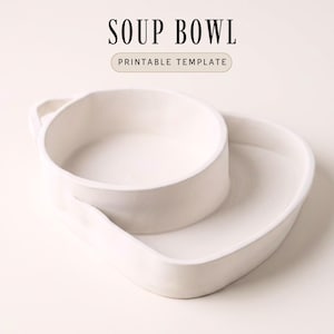May include: A white ceramic soup bowl with an attached side dish. The bowl has a handle and is labelled "SOUP BOWL PRINTABLE TEMPLATE" in black text.