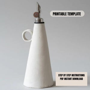 Pode incluir: Uma garrafa de óleo de cerâmica branca com um bico de aço inoxidável e uma pequena alça. A garrafa tem formato cônico e o texto "PRINTABLE TEMPLATE" e "STEP BY STEP INSTRUCTIONS PDF INSTANT DOWNLOAD" são visíveis.