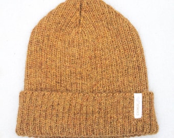 May include: A brown knitted beanie with a white label that says "CHIMUK".