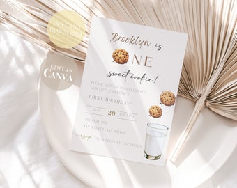 May include: A light-colored invitation card with the text "Brooklyn is ONE sweet cookie!" and illustrations of cookies and a glass of milk. The card includes details for a first birthday celebration, with the date June 29.