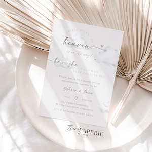 May include: A gender reveal invitation with the text "Little Piece of Heaven is on the way!" and "He or She". The invitation includes the names Melanie & Brian, date, time, and location. The design features watercolor clouds and a heart.