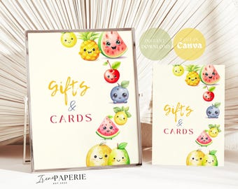 May include: A sign and a card featuring the text Gifts & Cards in yellow and red script and block lettering. The design includes watercolour illustrations of smiling fruits including a pineapple, watermelon, cherry, blueberry, and lemon.